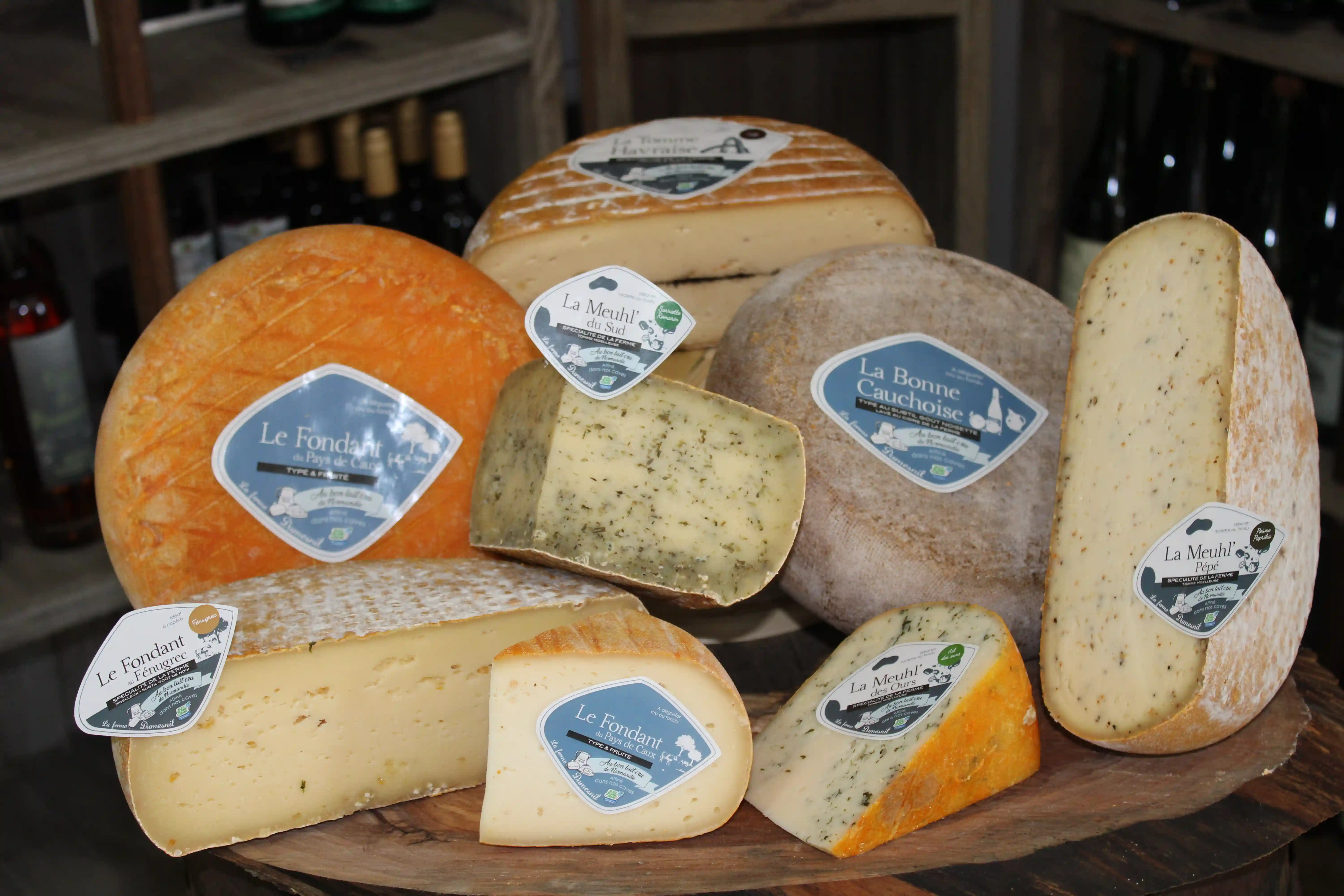 Photo d'un beau plateau de fromages sur une table accompagné d'une sélection de vins.